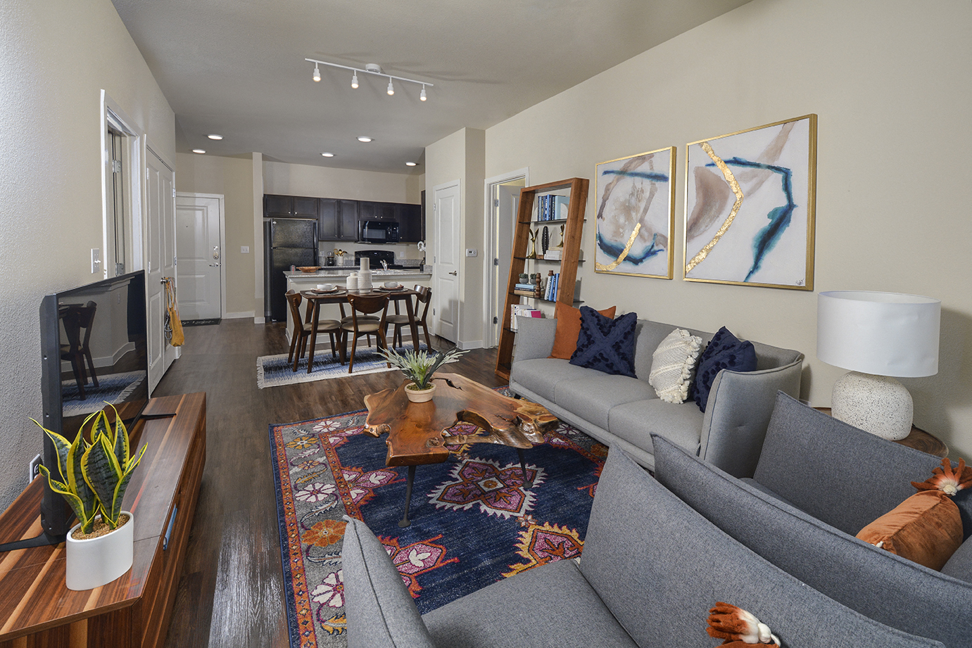A living room with a grey couch and a rug.