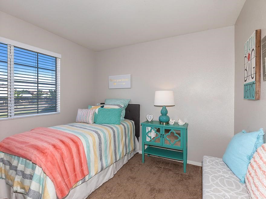 a bedroom with a bed and a table with a lamp