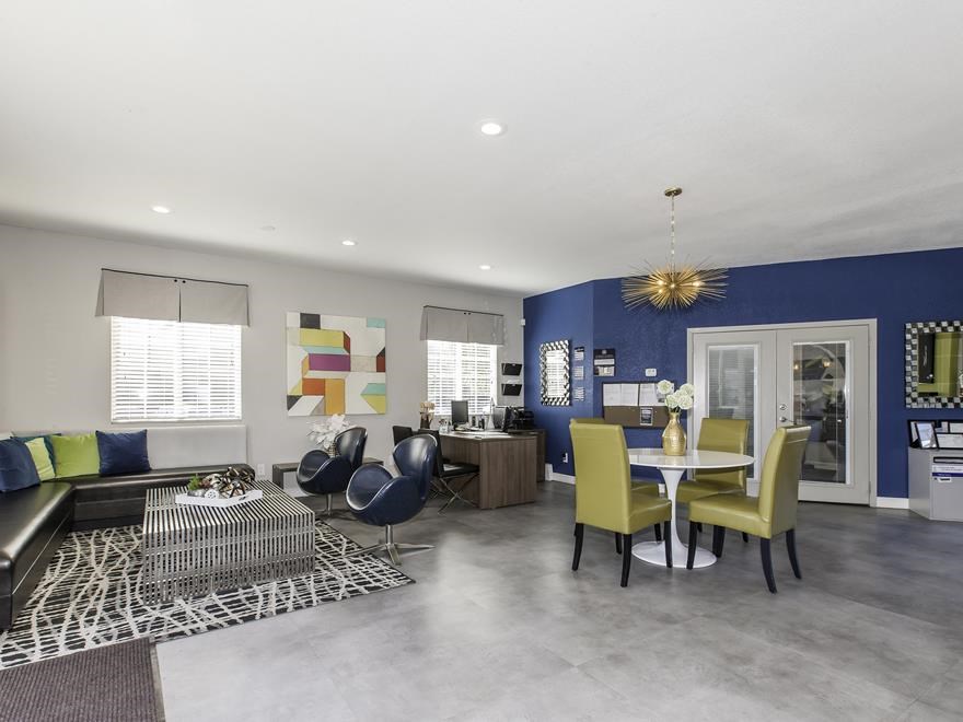 a living room and dining room with a blue accent wall
