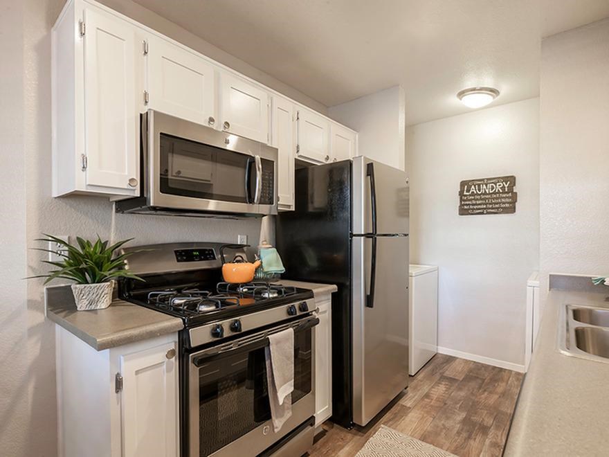 a kitchen with stainless steel appliances and a refrigerator