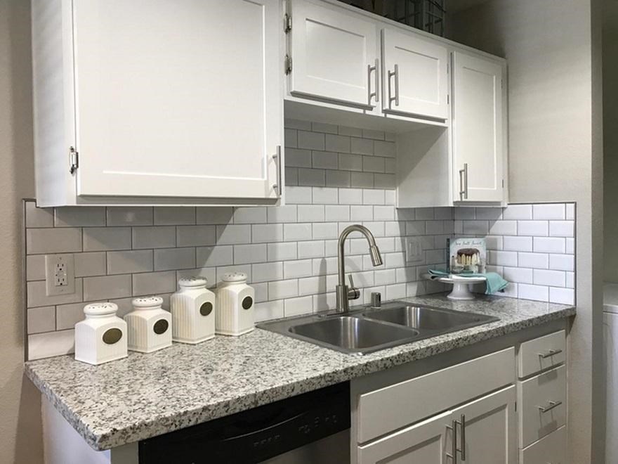 a kitchen with white cabinets and a sink