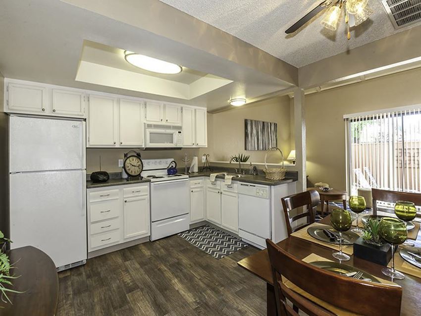 a kitchen with white appliances and a dining room table