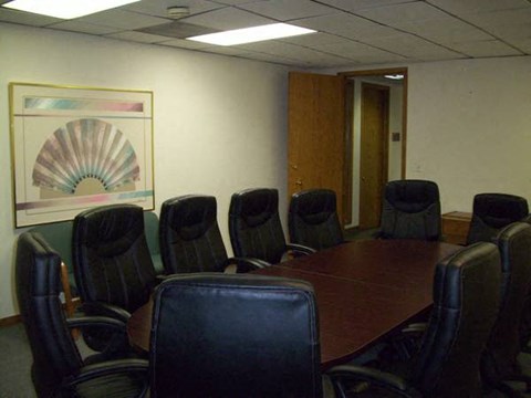 A conference room with a large table and chairs.