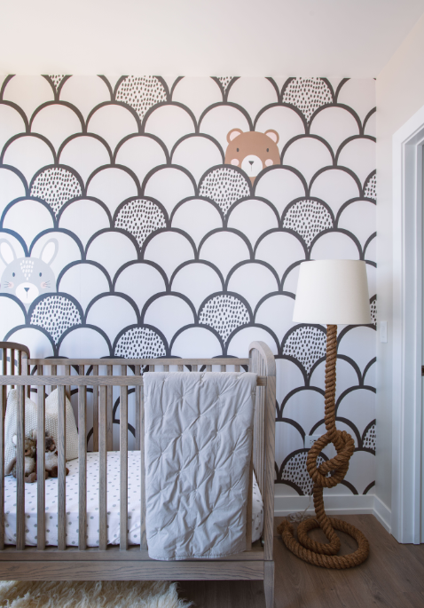 a baby nursery with a crib and a wall covered in wallpaper