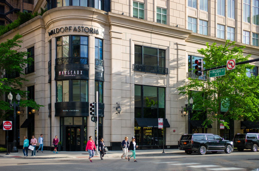 people crossing the street in front of a building on a city street
