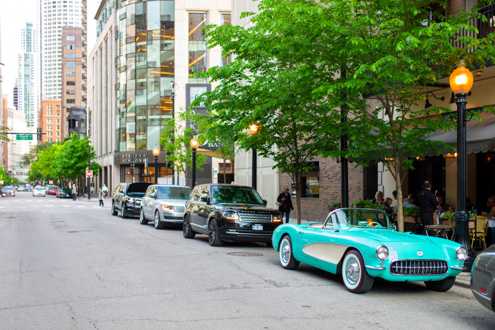 a classic car parked on the side of a city street
