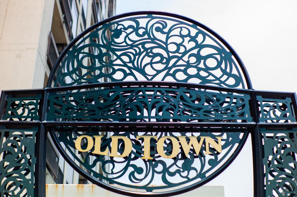 a sign for old town on a wrought iron gate