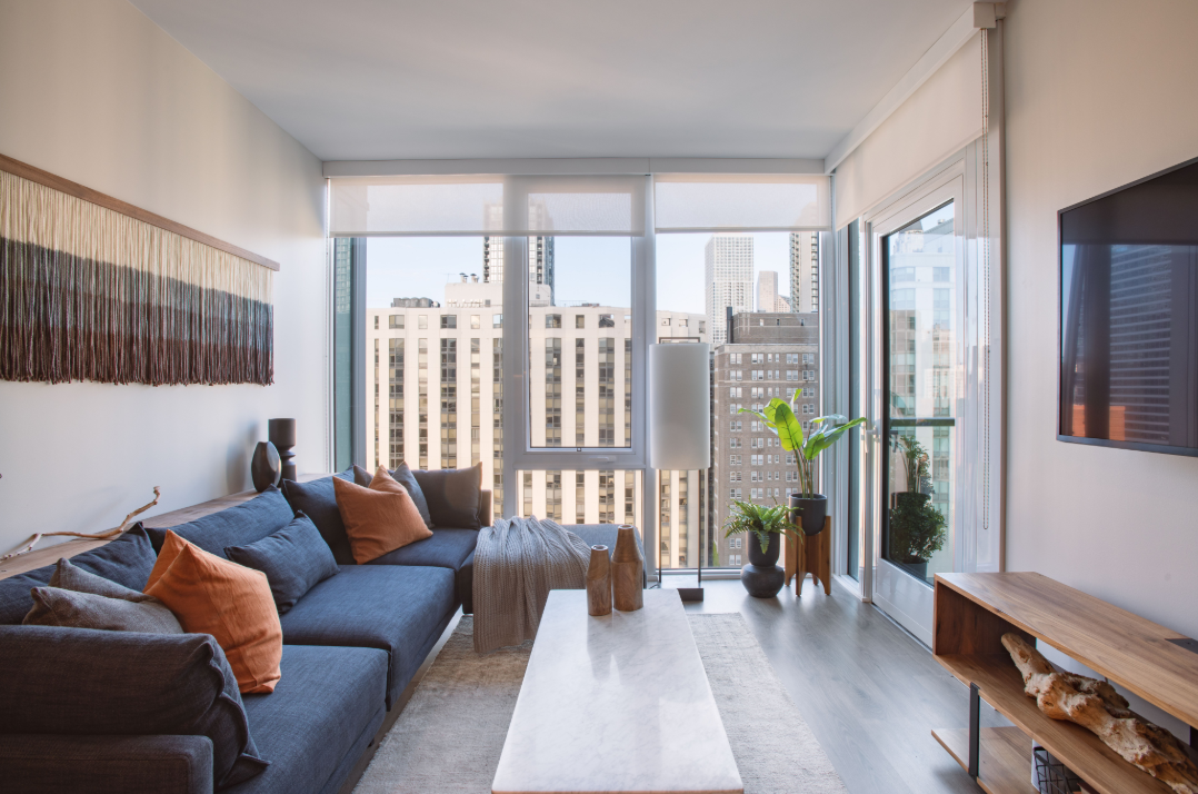 a living room with a blue couch and a large window