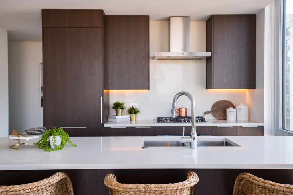 a kitchen with wooden cabinets and a white counter top and a sink