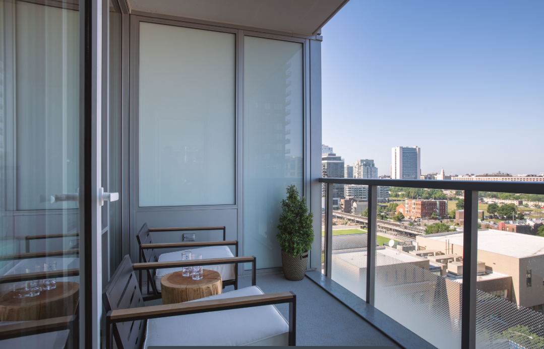 a balcony with a view of the city and a table and chairs