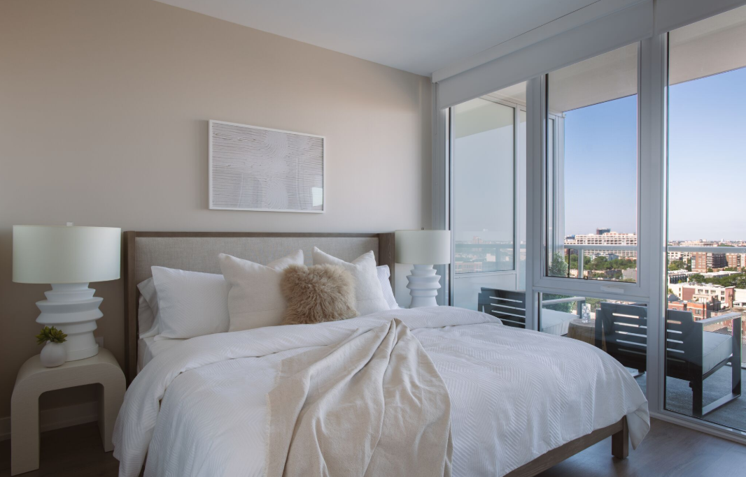 a bedroom with a large bed and a view of the city