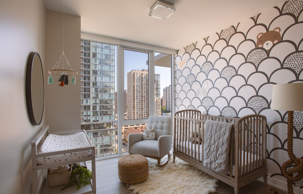 a baby room with a crib and a window with a city view