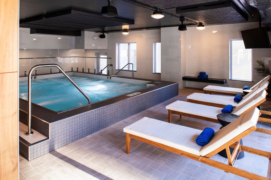 a spa with a hot tub and a pool table in a room