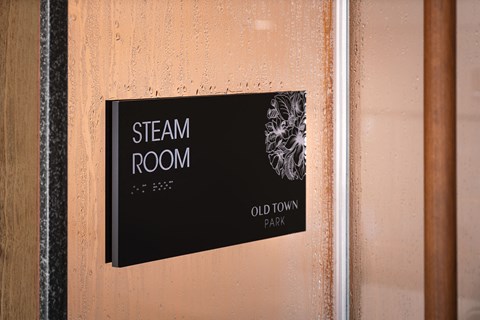 a sign that reads steam room on a wooden wall