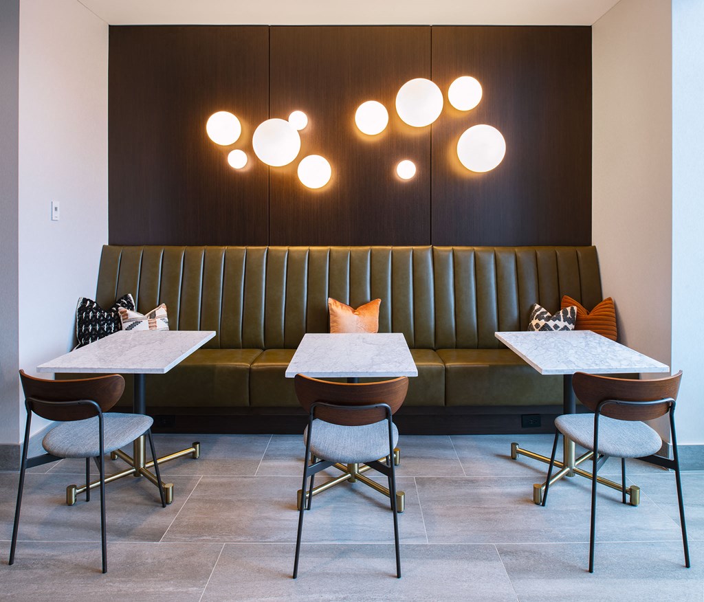 a dining room with tables and chairs and a green couch