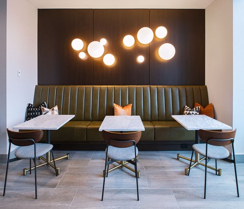 a dining room with tables and chairs and a green couch