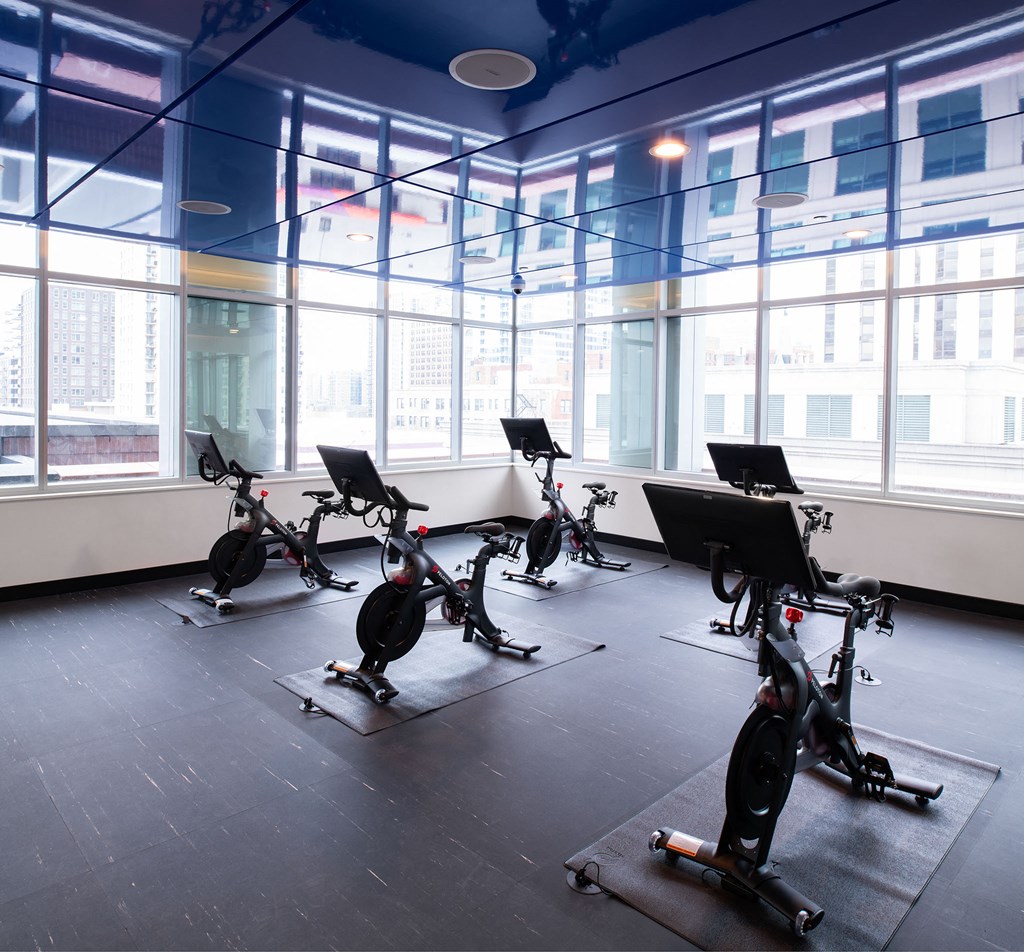 a gym full of exercise bikes in front of a window