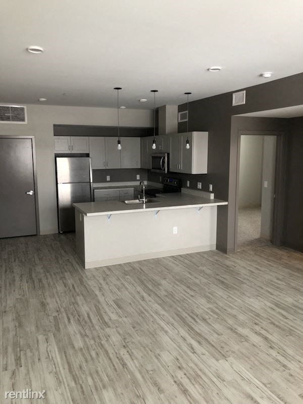 an empty kitchen with a sink and a refrigerator