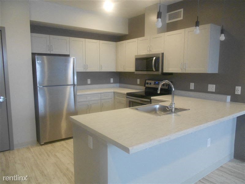 an empty kitchen with a sink and a refrigerator