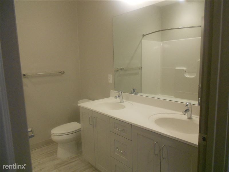 a bathroom with a toilet and a sink and a mirror