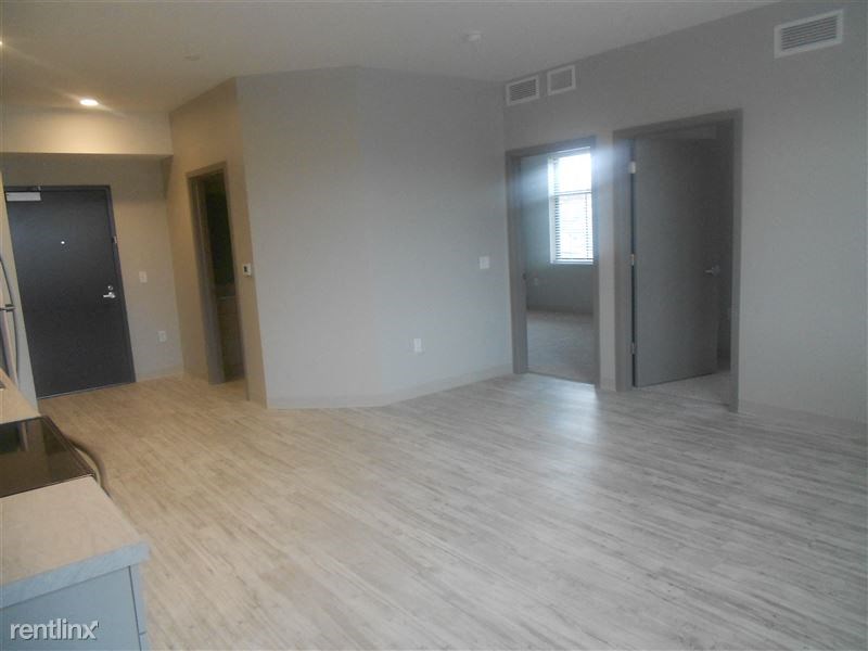 an empty living room with a hard wood floor
