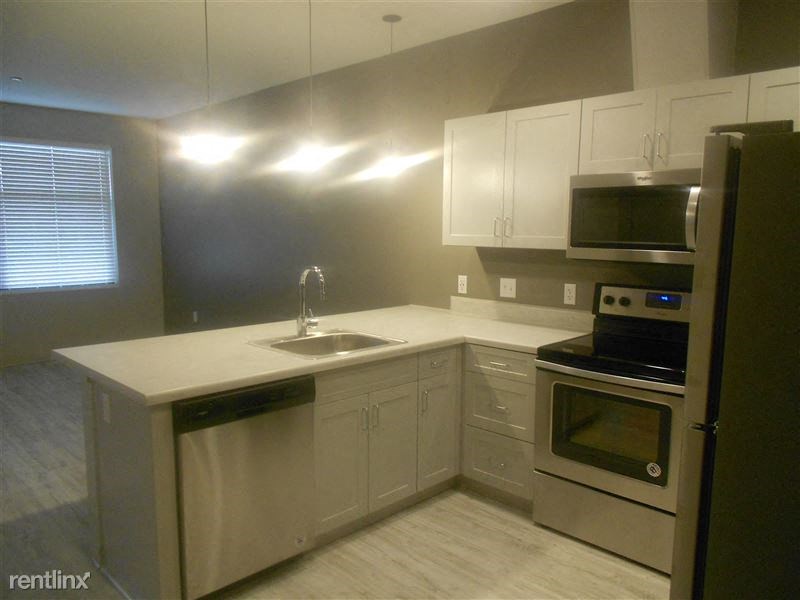 a kitchen with stainless steel appliances and white cabinets