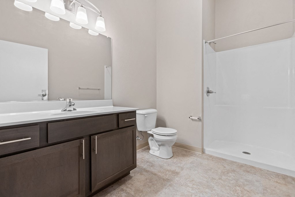 a bathroom with a toilet sink and shower and a mirror