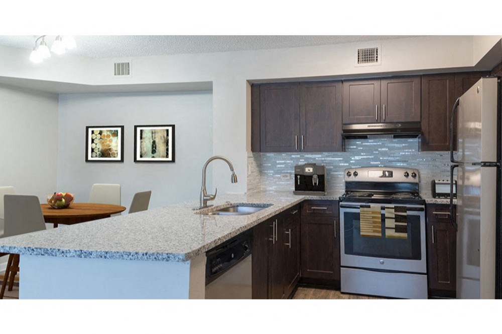 a kitchen with stainless steel appliances and a marble counter top