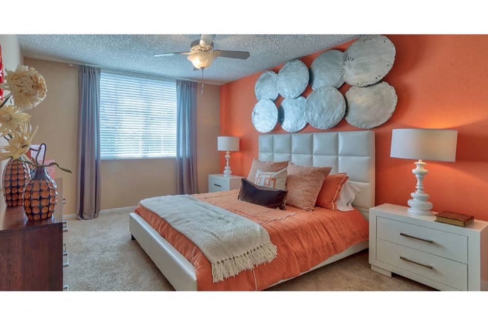 bedroom of a manufactured home with a bed and a ceiling fan