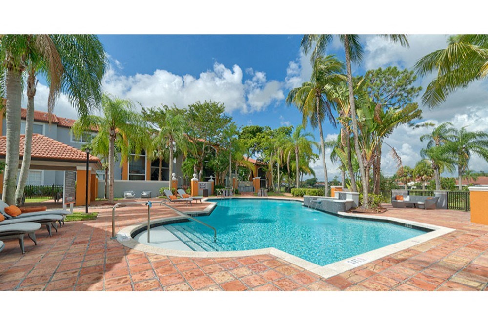 a large swimming pool with palm trees around it