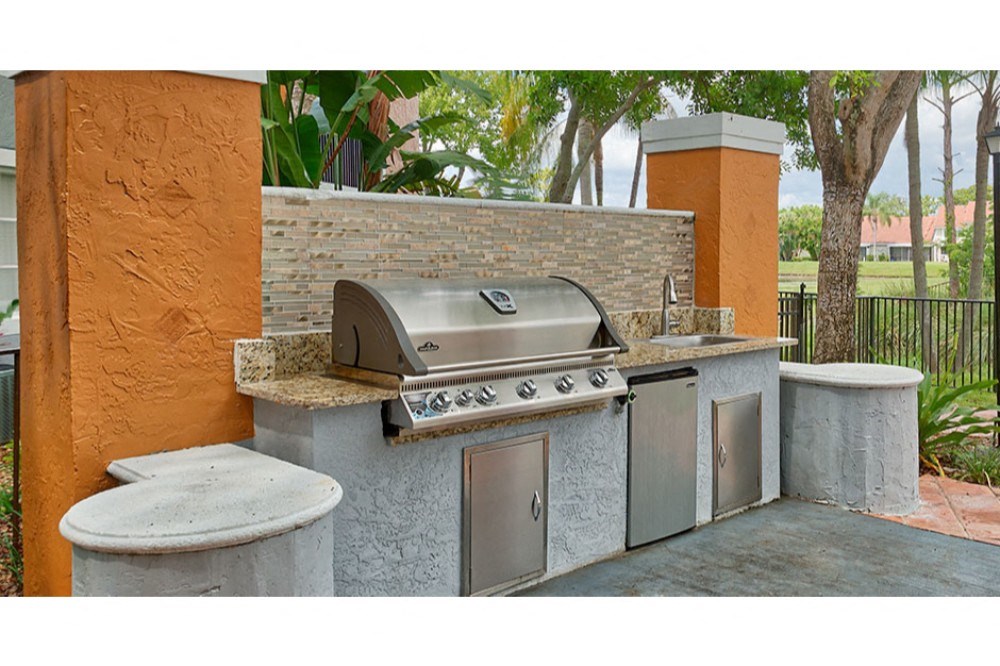an outdoor kitchen with a grill and a sink