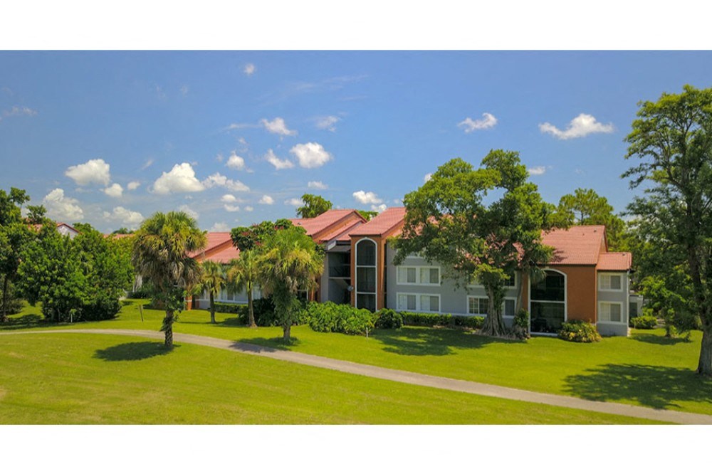 this is an image of a house with a green lawn and trees