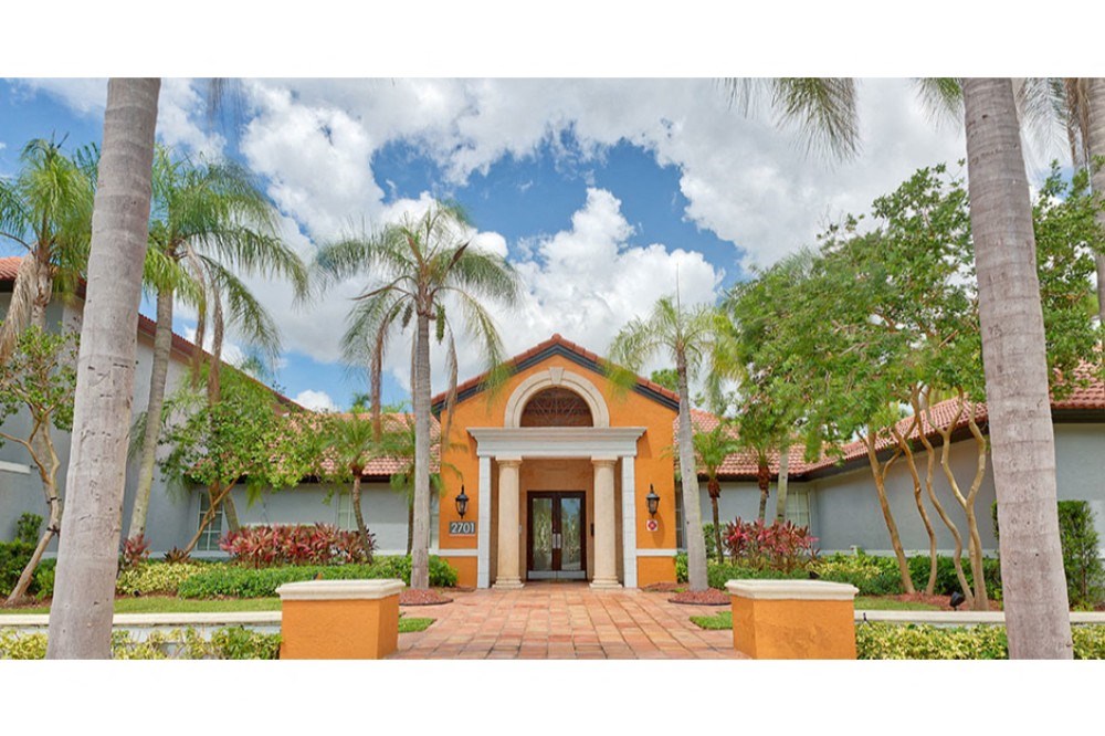 the front of a house with palm trees