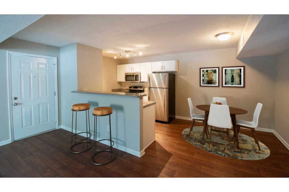 a kitchen and dining room with a table and stools