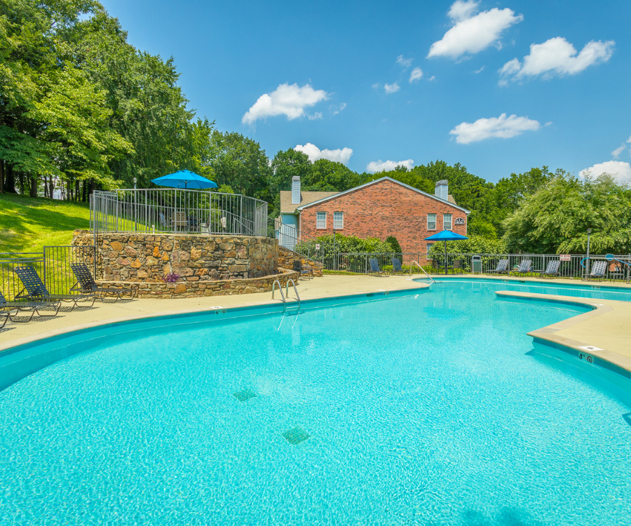 a swimming pool with a house in the background