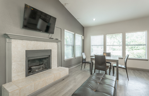 a living room with a fireplace and a table and chairs