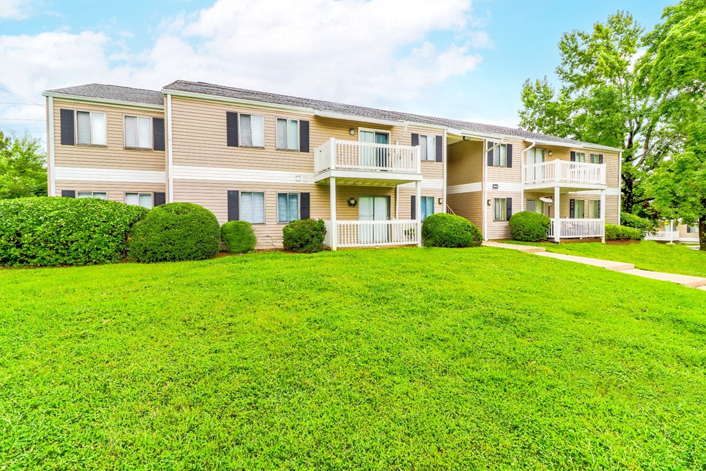 a large green lawn in front of an apartment building