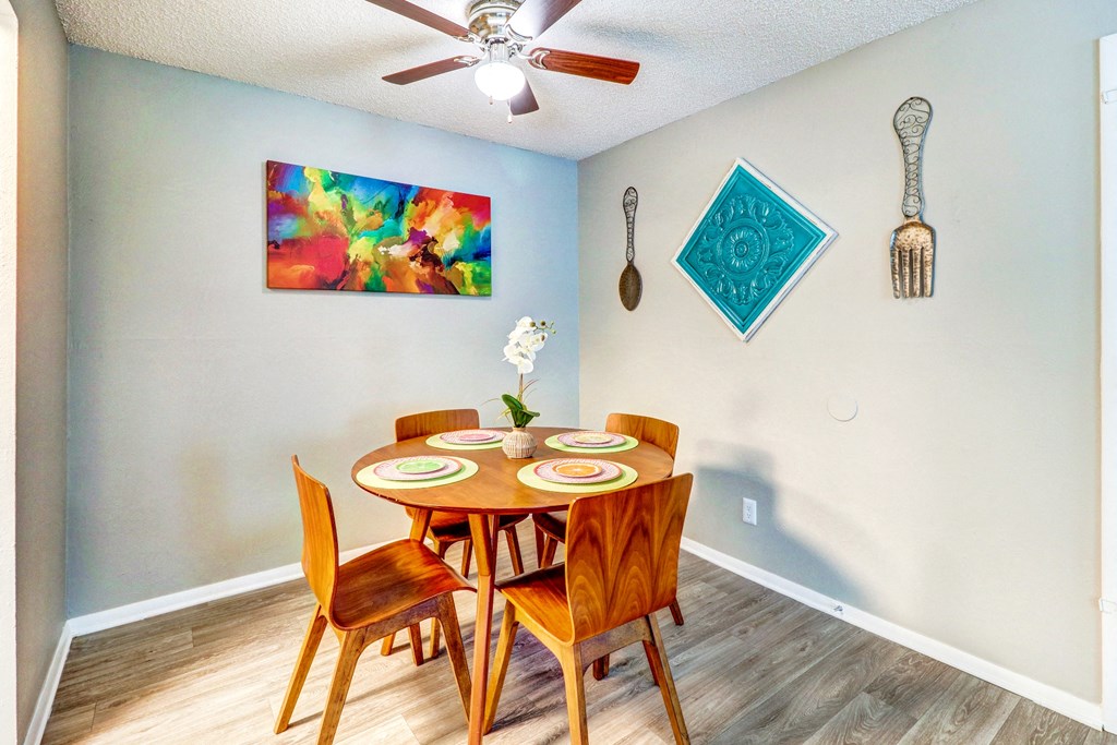 a dining room with a table and chairs and a ceiling fan