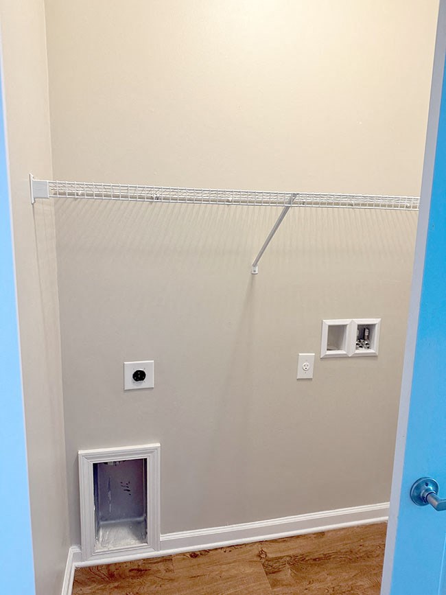 A white door with a small window in the middle of a wall.