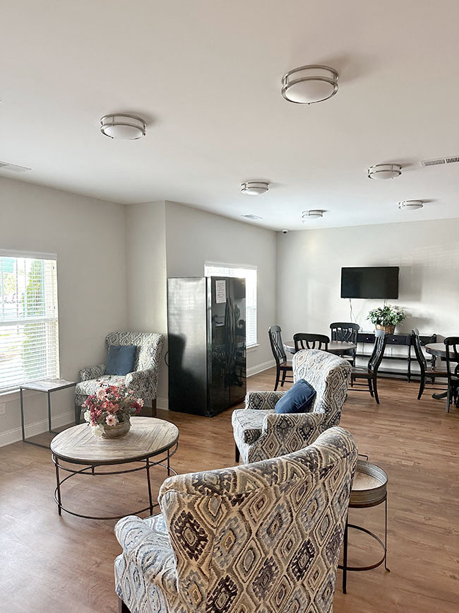 A living room with a patterned chair and a black cabinet.