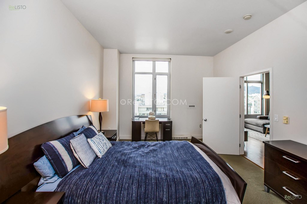 a bedroom with a large bed and a large window