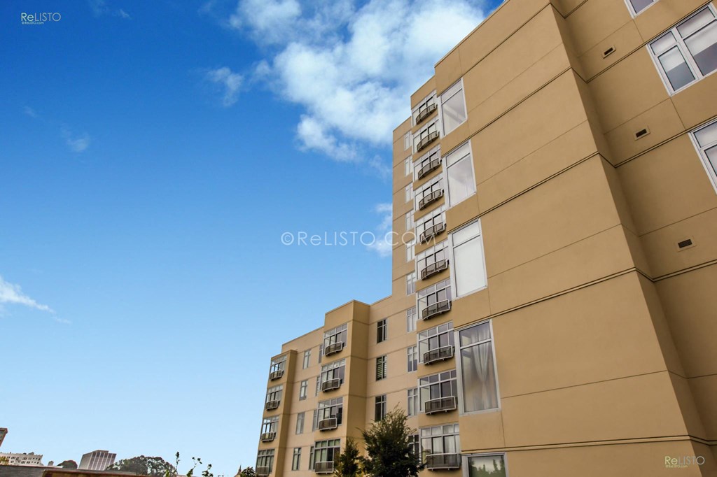 a view of an apartment building against a blue sky