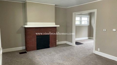 a fireplace in the living room of a home with gray walls and carpet