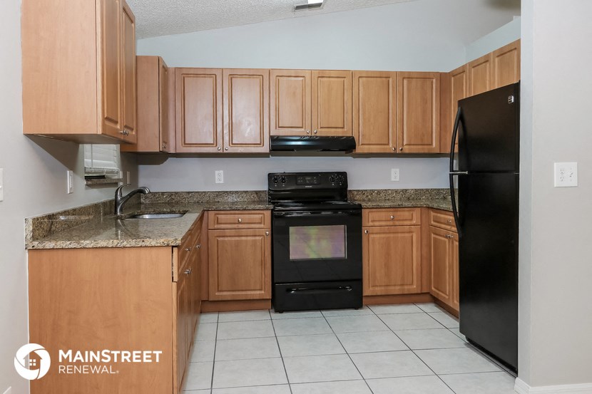 a kitchen with wooden cabinets and black appliances