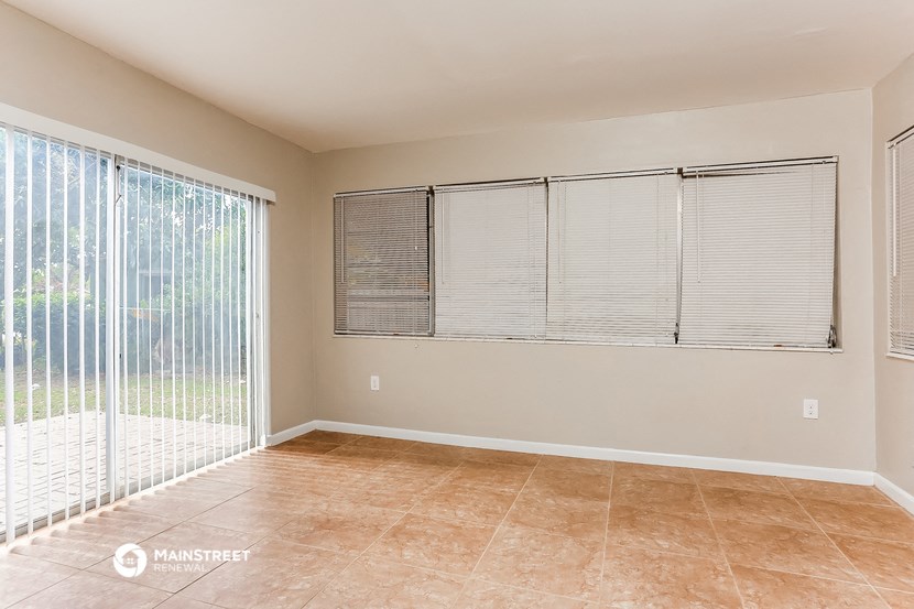 the living room of a home with a large window and blinds