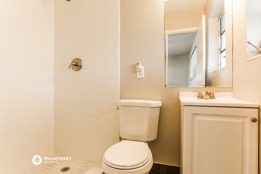 a bathroom with a toilet and a sink and a mirror