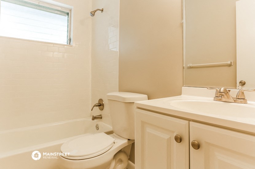 a bathroom with a toilet and a sink and a tub