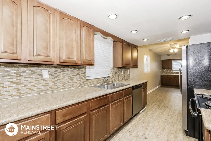 a kitchen with wooden cabinets and a stainless steel sink