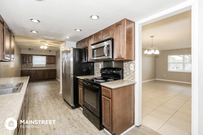 a kitchen with black appliances and wooden cabinets