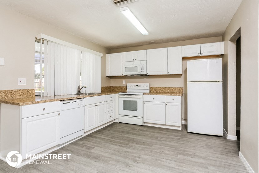 a white kitchen with white appliances and white cabinets